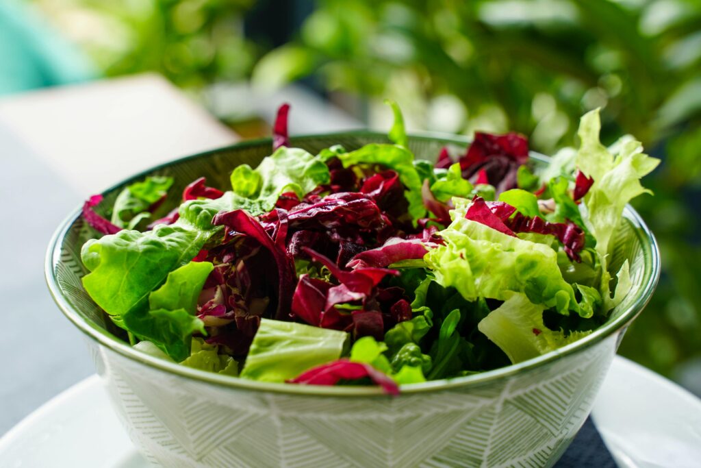 A colorful, leafy greens salad in a patterned bowl. Perfect for healthy eating inspiration.